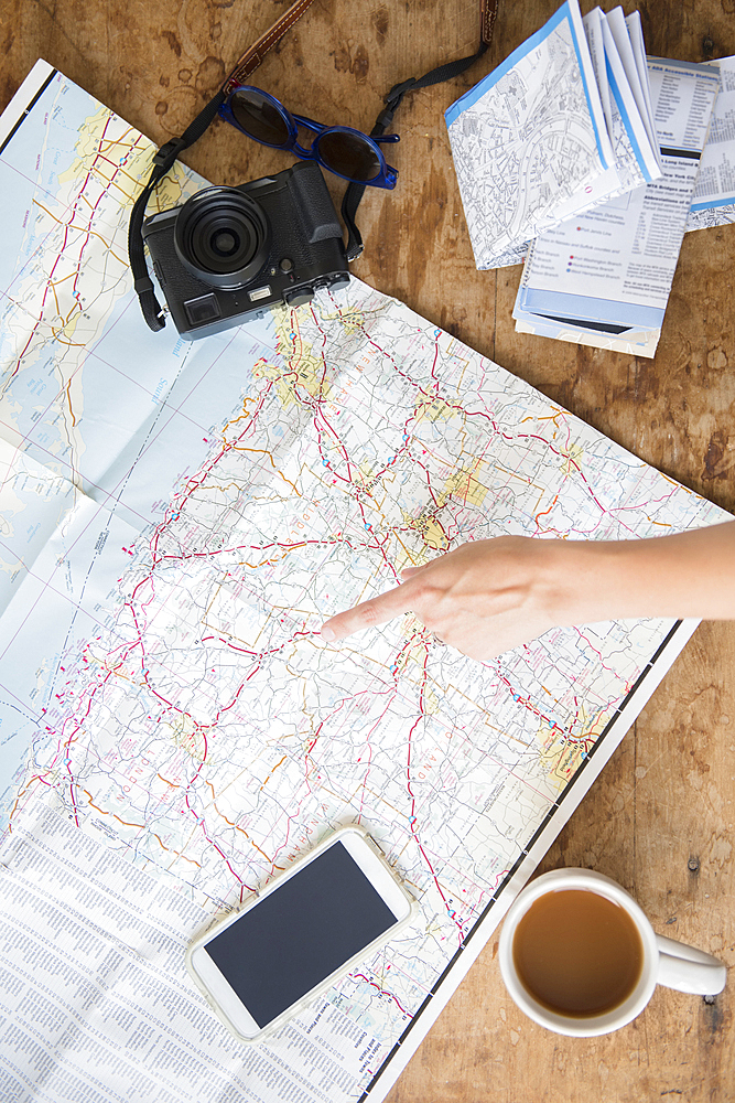 Finger of Caucasian woman pointing at map