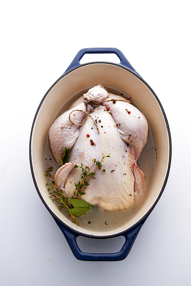 Raw whole chicken in pot