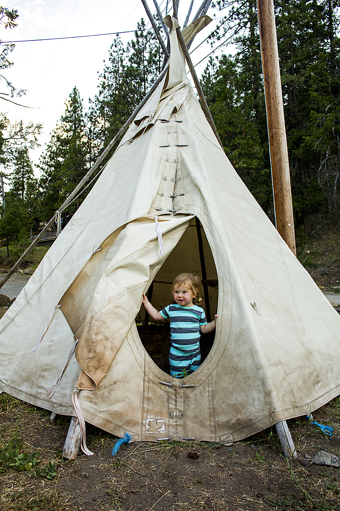 Caucasian girl standing in teepee