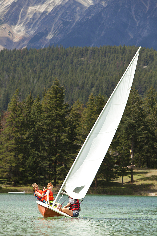 Caucasian boys and girl sailing on lake