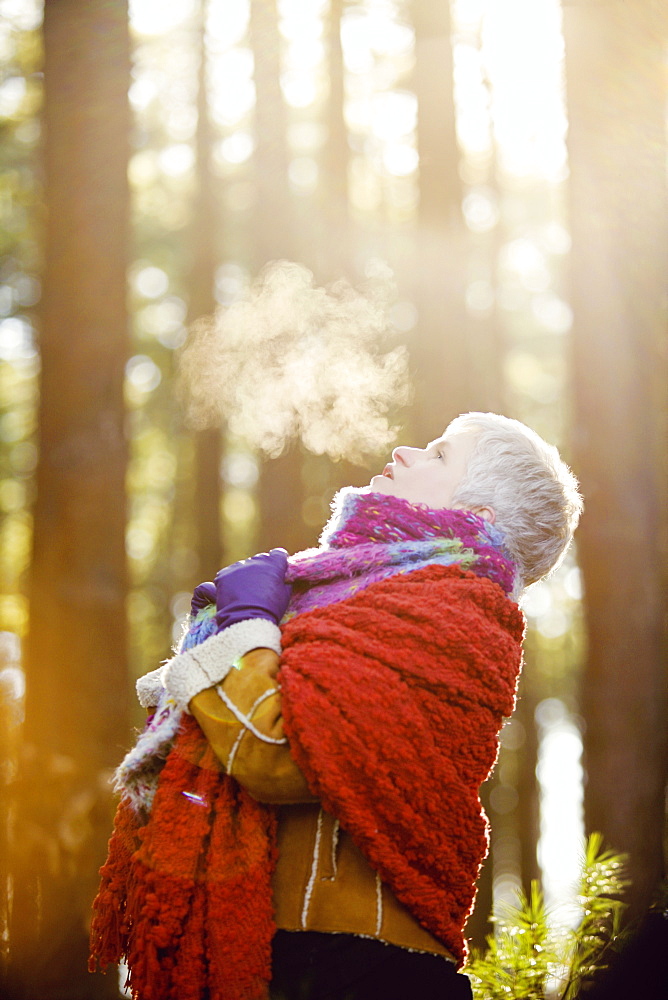 Older Caucasian woman breathing steam outdoors