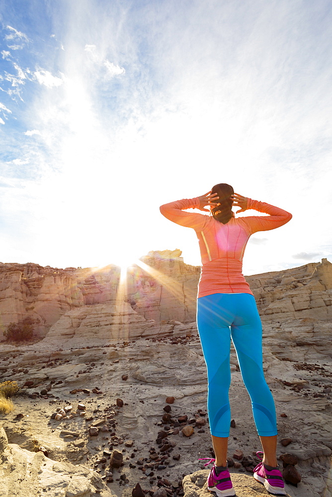 Woman standing in canyon stretching arms