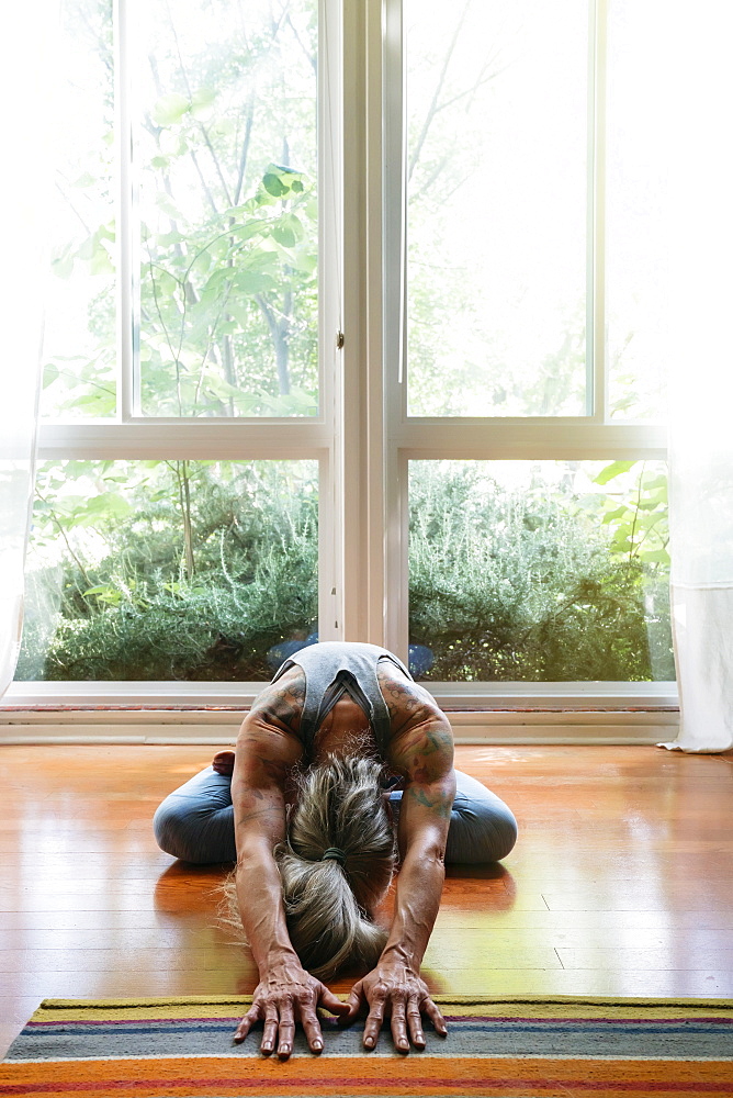 Caucasian woman stretching on floor