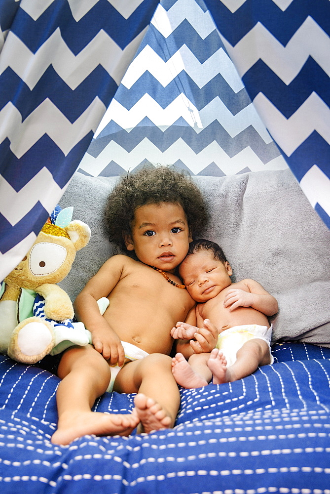 Mixed Race baby boys cuddling on bed