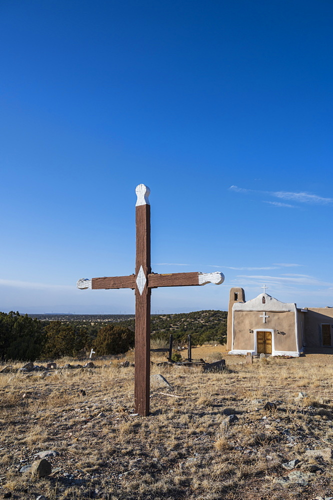 USA, New Mexico, Golden, San Francisco de Asis Church with old wooden cross in foreground