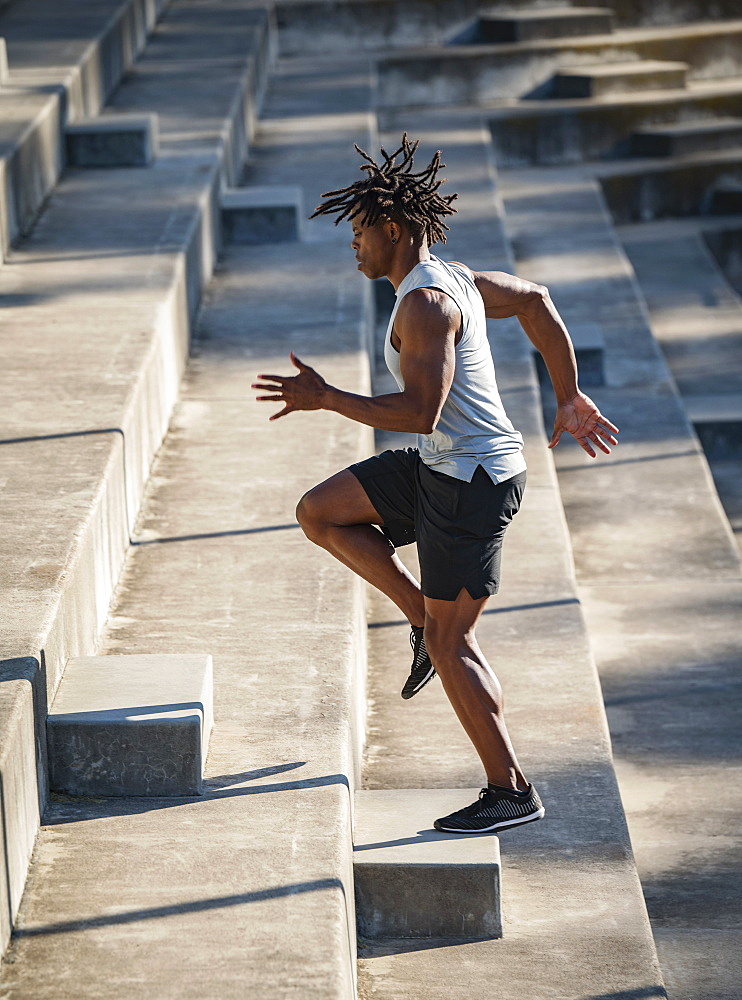 Athletic man running up steps