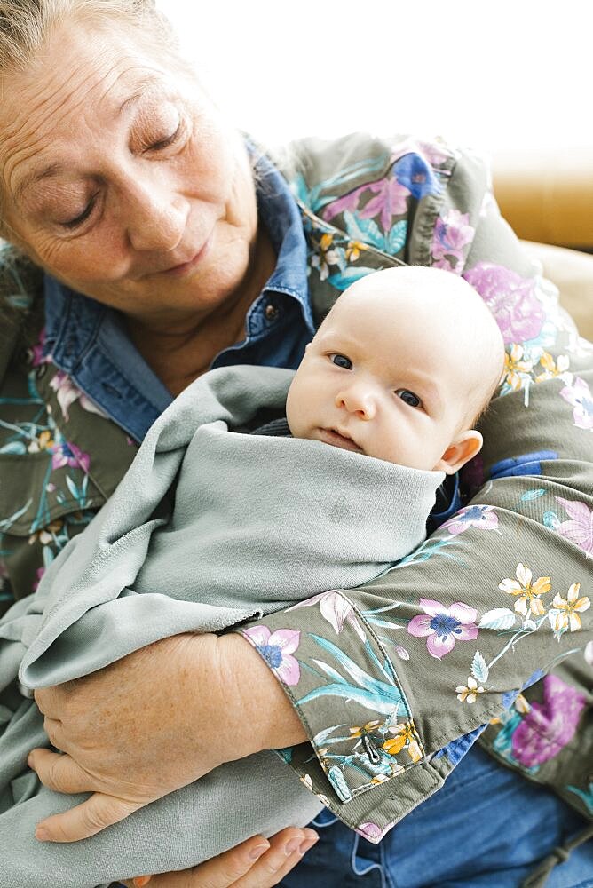 Grandmother holding newborn grandson (0-1 months)