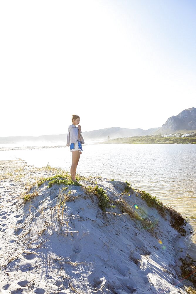 South Africa, Hermanus, Teenage girl (16-17) standing on sand dune