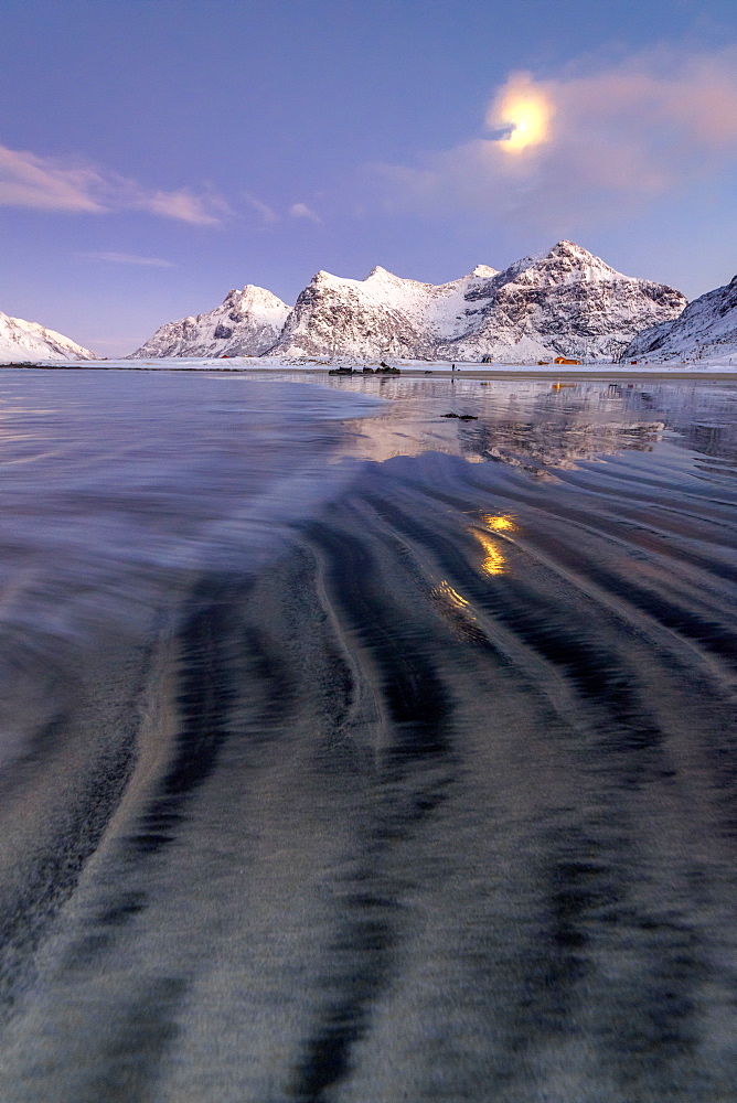 Full moon reflected in the icy sea around the surreal Skagsanden beach, Flakstad, Nordland county, Lofoten Islands, Arctic, Norway, Scandinavia, Europe