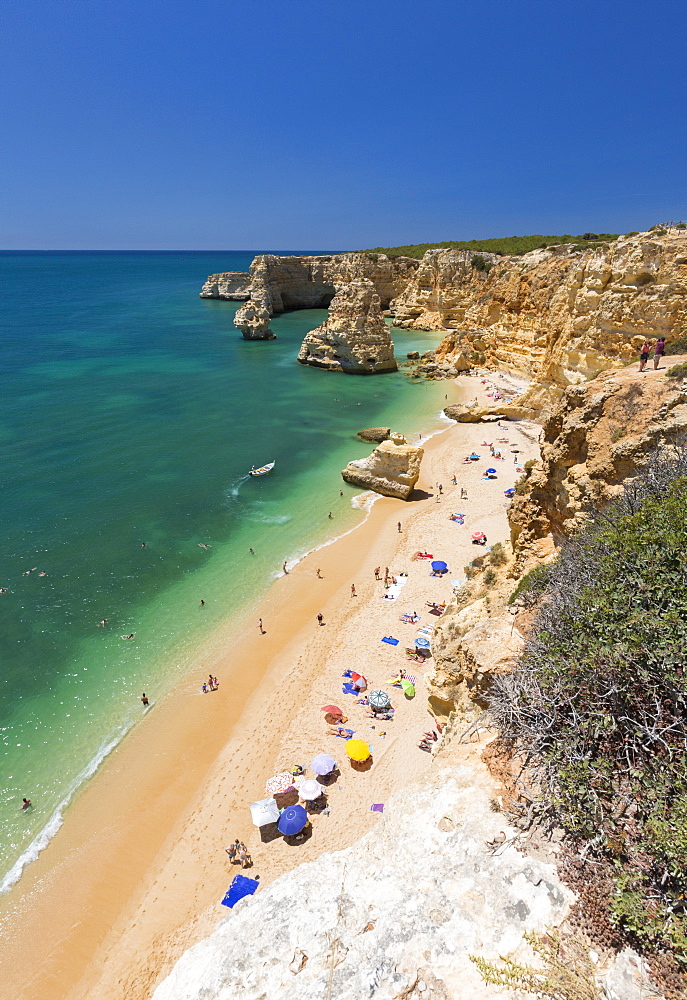 Tourists on sandy beach Praia da Marinha surrounded by turquoise ocean, Caramujeira, Lagoa Municipality, Algarve, Portugal, Europe