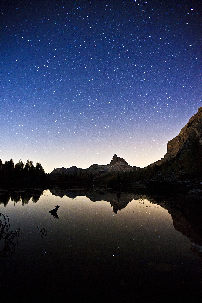 The Milky Way reflecting in Lake Federa, with the Becco di Mezzodi, in the background. Dolomites, South Tyrol, Italy, Europe