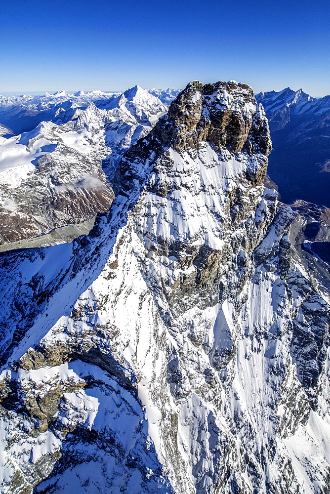 The massive shape of the Matterhorn sorrounded by its mountain range covered in snow, Swiss Canton of Valais, Swiss Alps, Switzerland, Europe