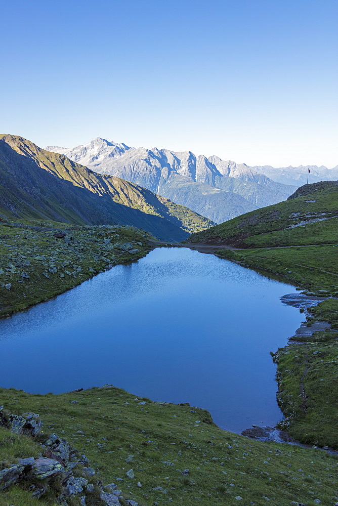 The alpine lake frames the green valley and Rifugio Bozzi, Val Di Viso, Camonica Valley, province of Brescia, Lombardy, Italy, Europe