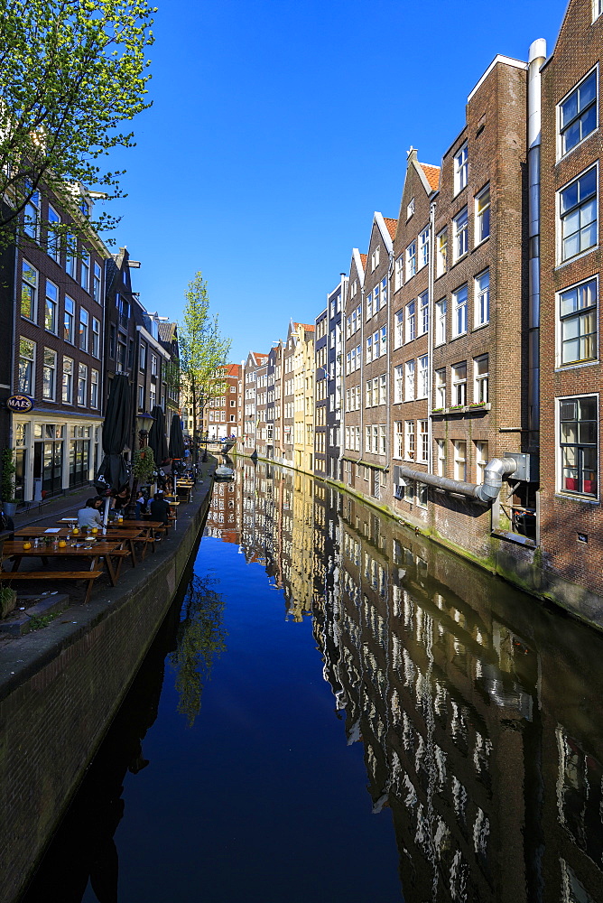 Typical houses reflected in the blue water of a canal, Amsterdam, Holland (The Netherlands), Europe