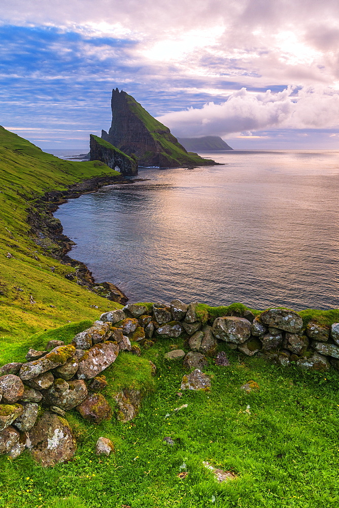 Sunset on the calm ocean and Drangarnir rock, Vagar island, Faroe Islands, Denmark, Europe