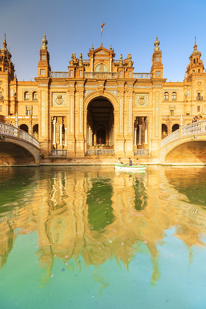 Facade the old palace built in Neo-Mudejar style reflected in the canal, Plaza de Espana, Seville, Andalusia, Spain, Europe