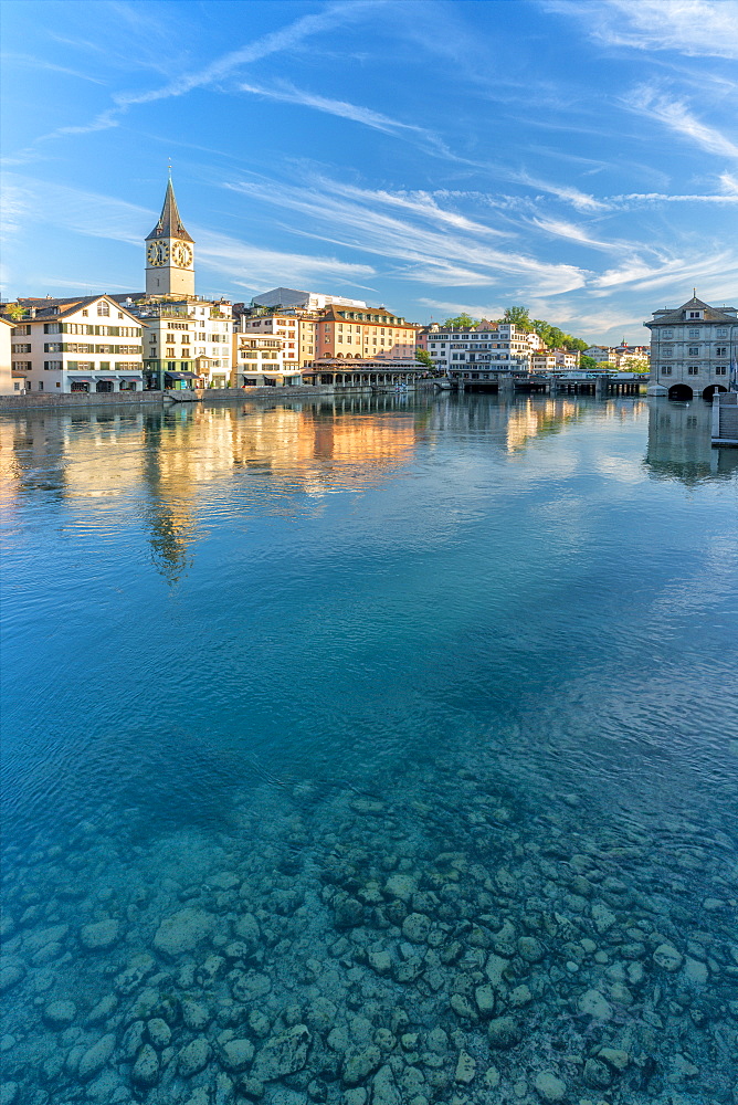 Clock tower of St. Peter church mirrored in the turquoise water of Limmat River, Lindenhof, Zurich, Switzerland, Europe