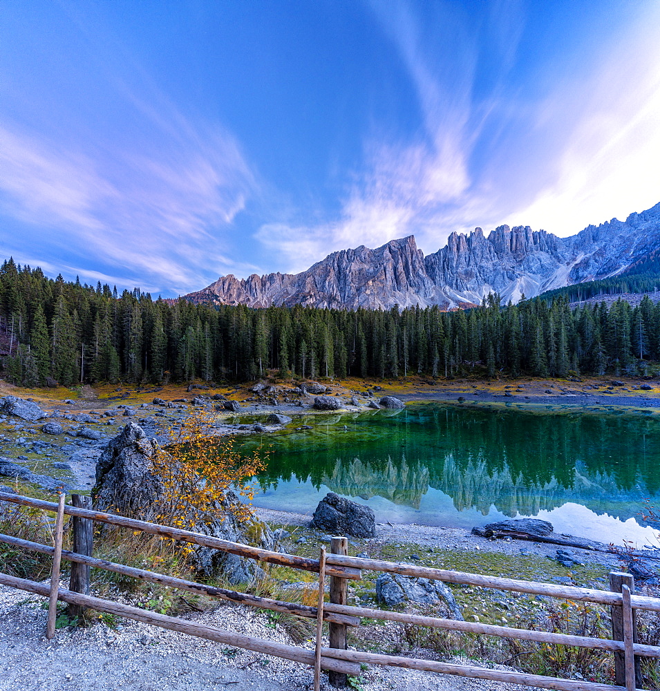 Dramatic sky at sunset over Carezza Lake and Latemar peaks in autumn, Dolomites, South Tyrol, Italy, Europe