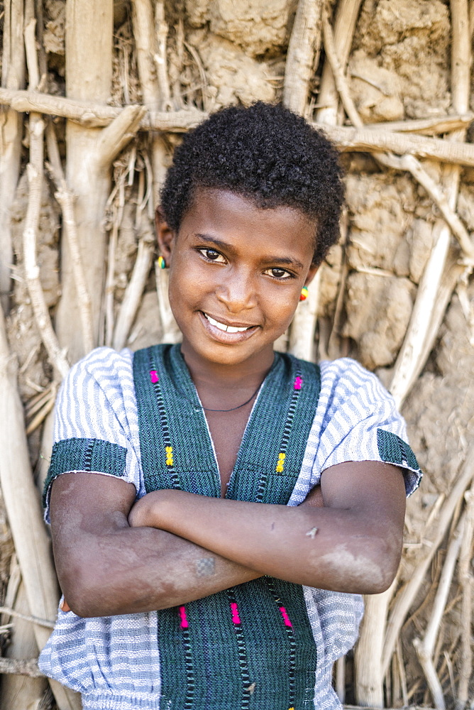 Portrait of girl with crossed arms smiling at camera, Abala, Afar Region, Ethiopia, Africa