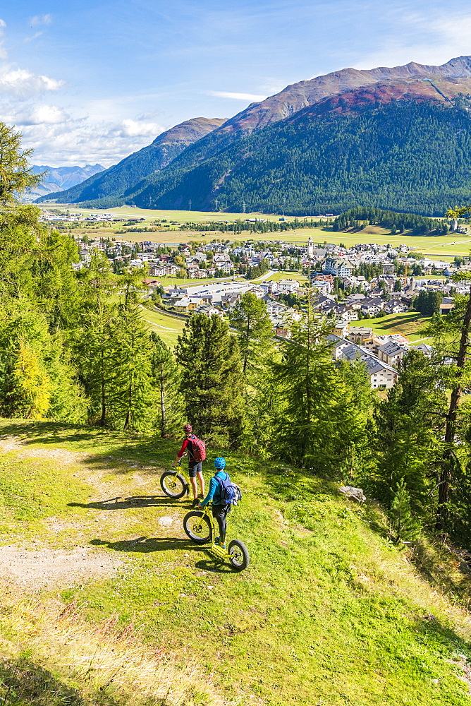 People on downhill scooters admiring the village of Celerina along the trail, Engadine, canton of Graubunden, Switzerland, Europe