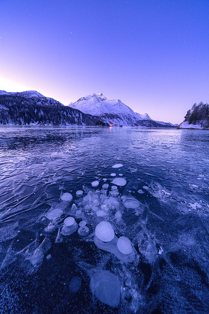 Ice bubbles trapped in Lake Sils with Piz Da La Margna in background at dawn, Engadine, Graubunden canton, Switzerland, Europe