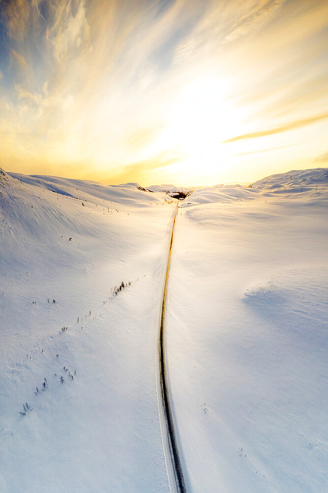 Aerial view of burning sky at dawn over the scenic road crossing the snowy mountains, Sennalandet, Alta, Troms og Finnmark, Arctic, Norway, Scandinavia, Europe