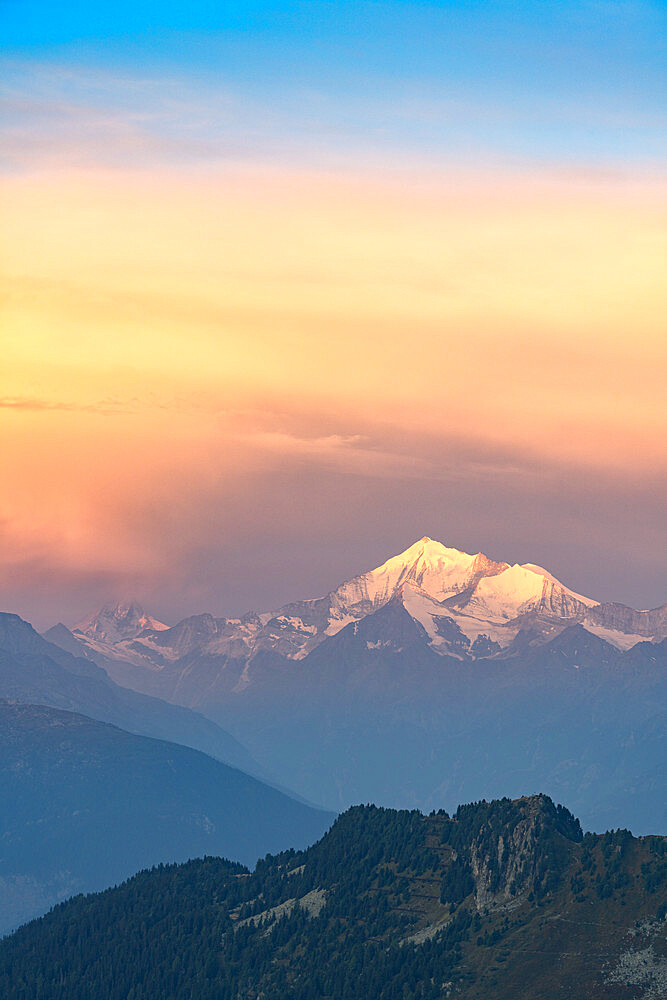 Clouds in the misty sky at dawn over Matterhorn and snow capped Weisshorn peak, Pennine Alps, Valais canton, Switzerland, Europe