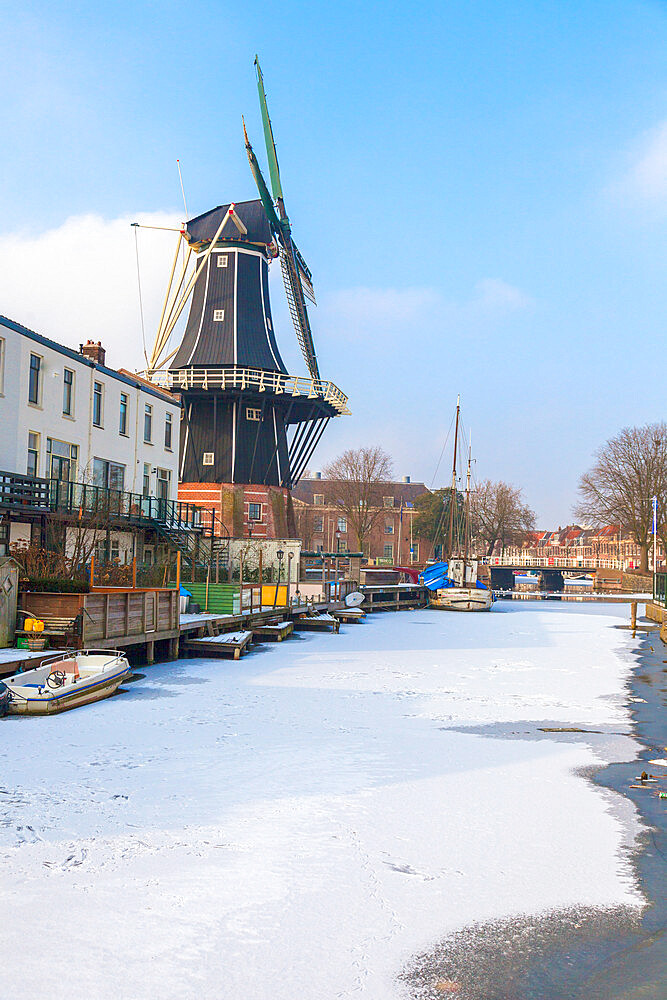 Windmill De Adriaan along the frozen canal of Spaarne river, Haarlem, Amsterdam district, North Holland, The Netherlands, Europe