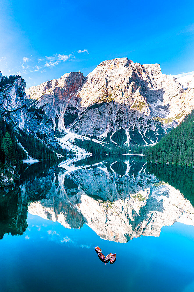 Lake Braies (Pragser Wildsee) with Croda del Becco reflected in water at dawn, aerial view, Dolomites, South Tyrol, Italy, Europe