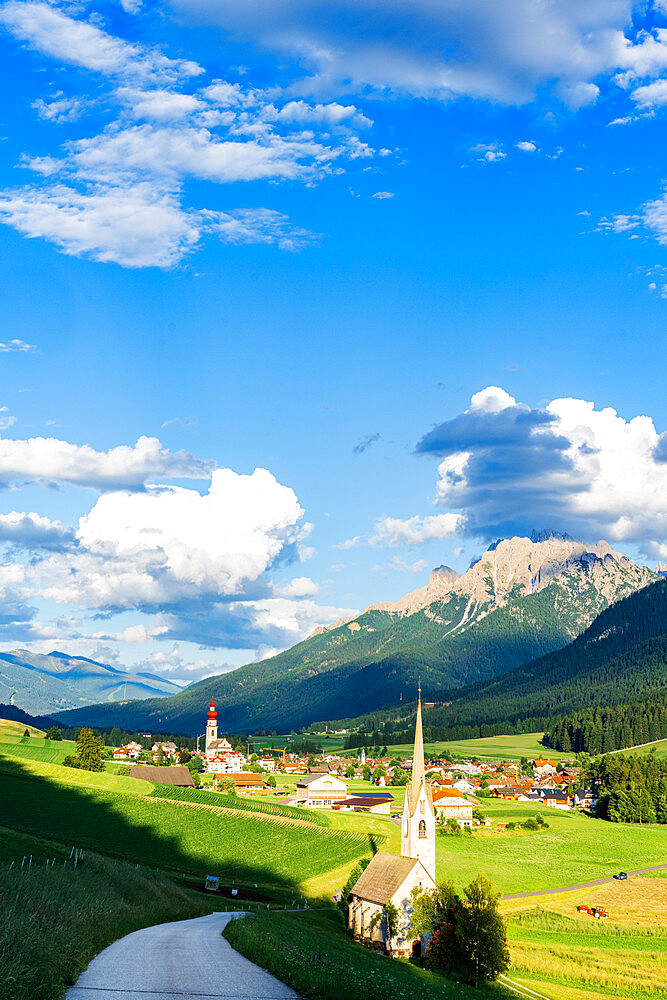 Sunshine over green pastures and village of Villabassa (Niederdorf) in summer, Val Pusteria, Bolzano province, South Tyrol, Italy, Europe