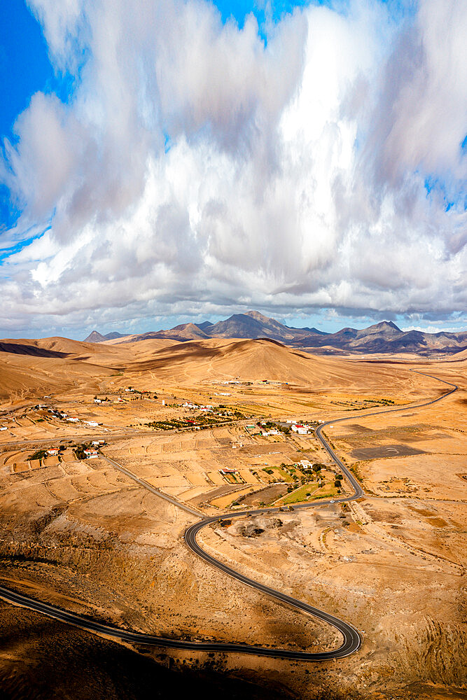 Scenic clouds on winding road running through desert mountains, aerial view, Tefia, Fuerteventura, Canary Islands, Spain, Atlantic, Europe