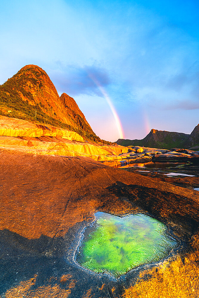 Algae inside rock formation on cliffs lit by rainbow during the midnight sun, Tungeneset, Senja, Troms county, Norway, Scandinavia, Europe