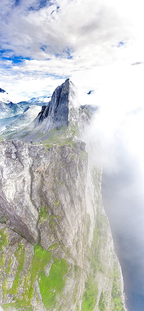 Aerial view of two hikers walking towards the scenic Segla Mountain in a sea of clouds, Senja island, Troms county, Norway, Scandinavia, Europe