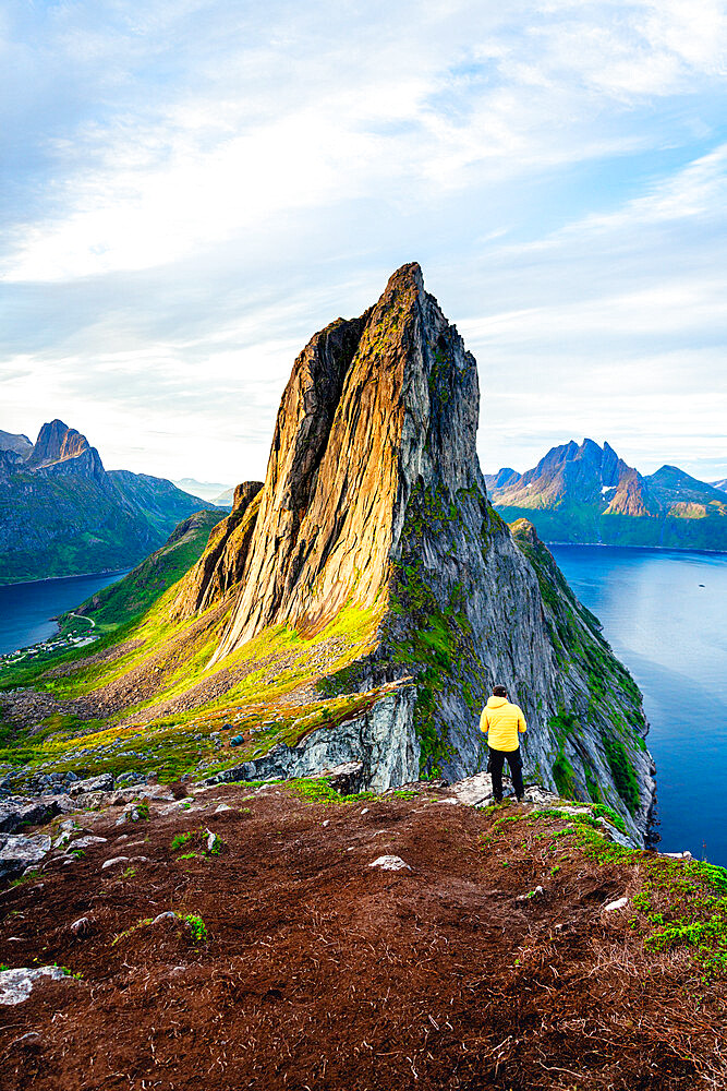 Person standing in front of tall Segla Mountain and fjords at dawn, Senja island, Troms county, Norway, Scandinavia, Europe