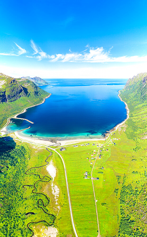 Aerial view of road in green meadows leading to the scenic Ersfjord beach washed by the crystal sea, Senja, Troms, Norway, Scandinavia, Europe