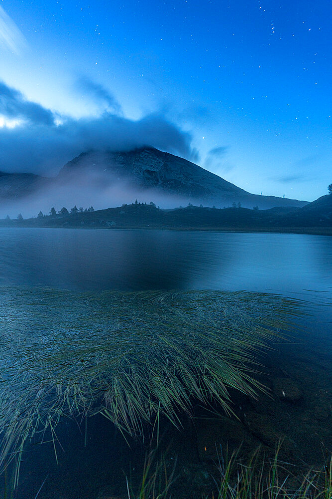 Calm water of Hopschusee lake during blue hour, Simplon Pass, Valais Canton, Swiss Alps, Switzerland, Europe