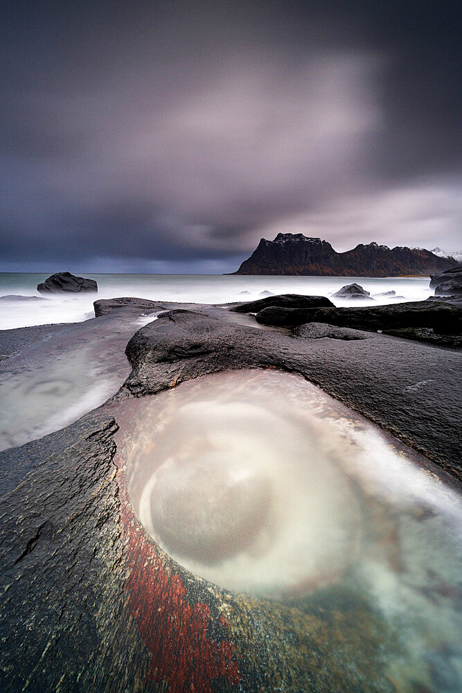 Storm clouds over The Eye rock formation washed by waves, Uttakleiv, Leknes, Vestvagoy, Nordland, Lofoten Islands, Norway, Scandinavia, Europe