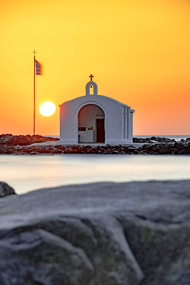 Sun rising over the iconic Agios Nikolaos church and cliffs, Georgioupolis, Crete island, Greek Islands, Greece, Europe