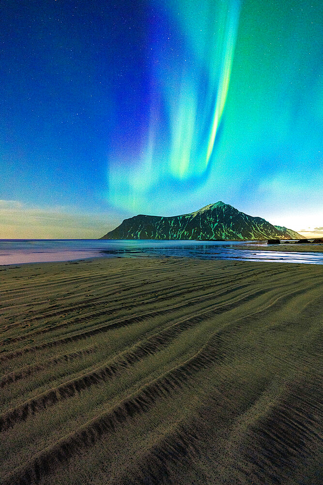 Rough sand of Skagsanden beach lit by green lights of Aurora Borealis (Northern Lights), Flakstad, Lofoten Islands, Norway, Scandinavia, Europe