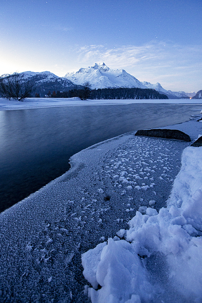 Winter sunrise over the frozen surface of Lake Sils in winter, Engadine, Canton of Graubunden, Switzerland, Europe