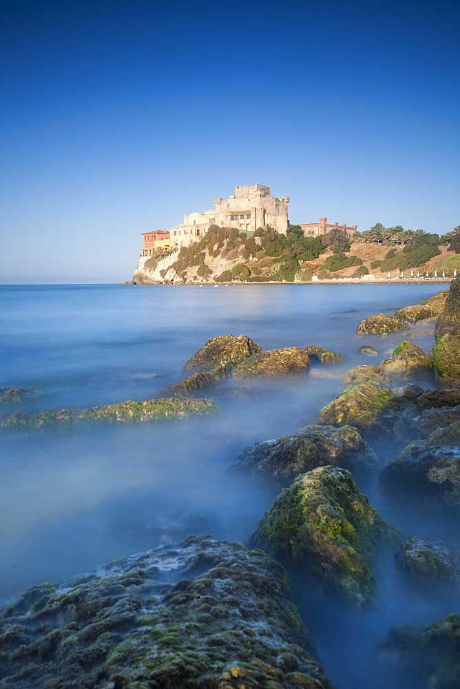 Alongside a picturesque millstone, atop a rocky promontory dominating the sea, rises the Castello di Falconara, Sicily, Italy, Mediterranean, Europe