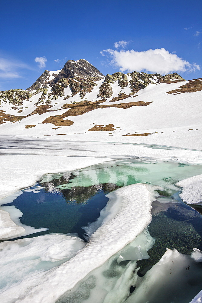 Spring is coming and lake Emet in the Spluga Valley is slowly thawing, Lombardy, Italy, Europe