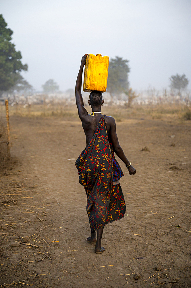 Mundari woman with water canister on her head, Mundari tribe, South Sudan, Africa