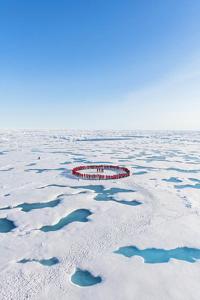 People wearing red forming circle around North Pole, Arctic