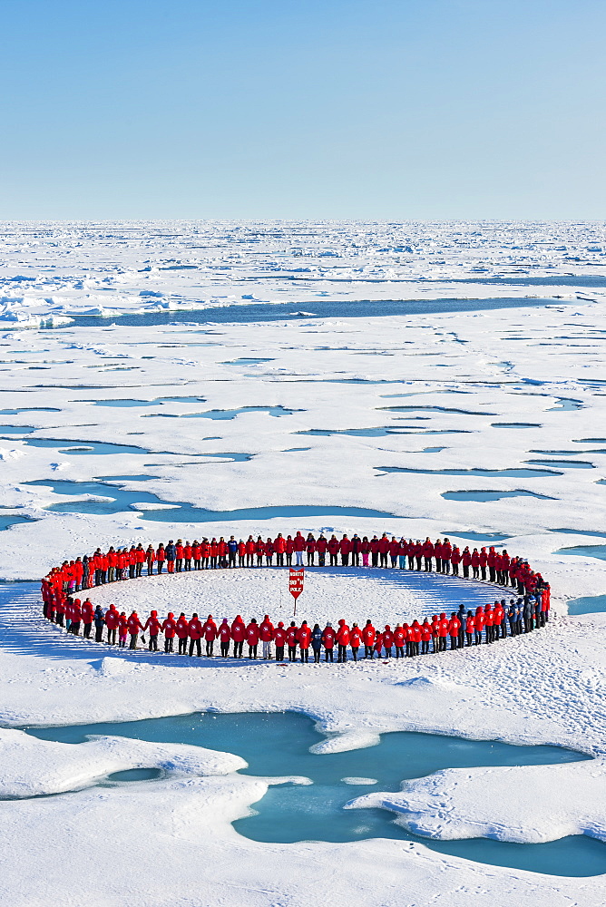 People wearing red forming circle around North Pole, Arctic