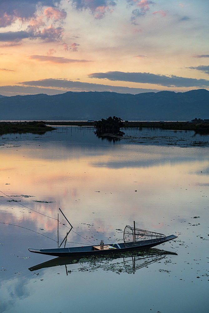 Clouds and traditional rowing boat reflecting in the water at sunset, Inle Lake, Shan state, Myanmar (Burma), Asia