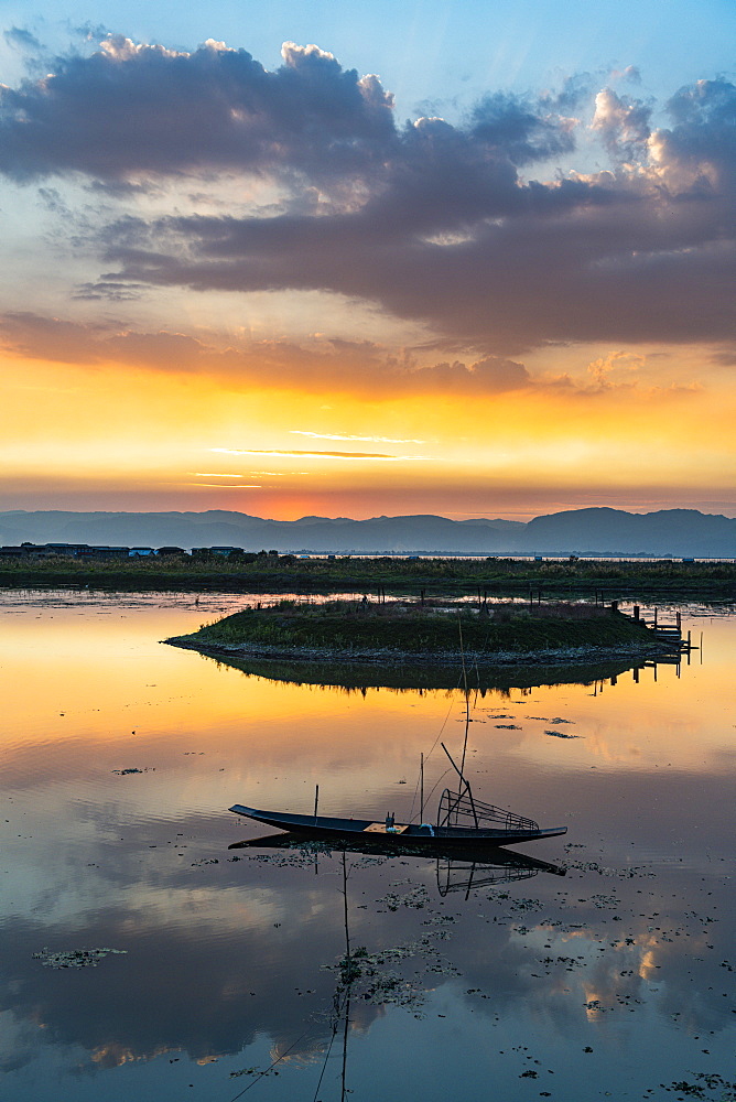 Clouds and traditional rowing boat reflecting in the water at sunset, Inle Lake, Shan state, Myanmar (Burma), Asia