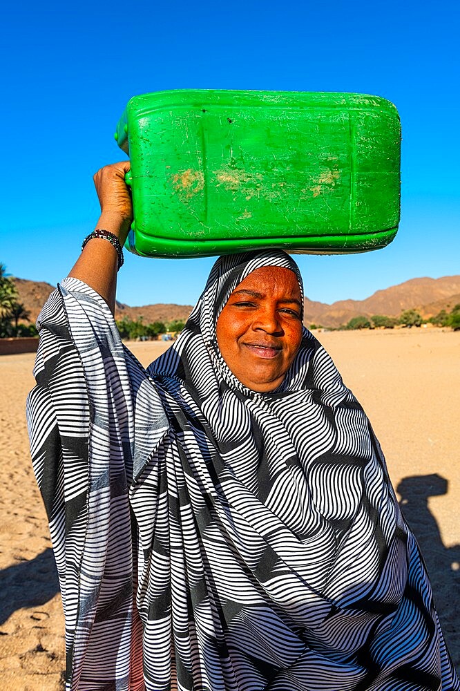 Woman carrying a water container on her head, Oasis of Timia, Air Mountains, Niger, Africa