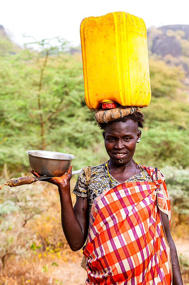 Woman with a water caniister on her head, Laarim tribe, Boya Hills, Eastern Equatoria, South Sudan, Africa