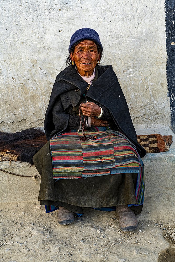 Old woman with a prayer wheel in her hand, Lo Manthang, Kingdom of Mustang, Nepal, Asia